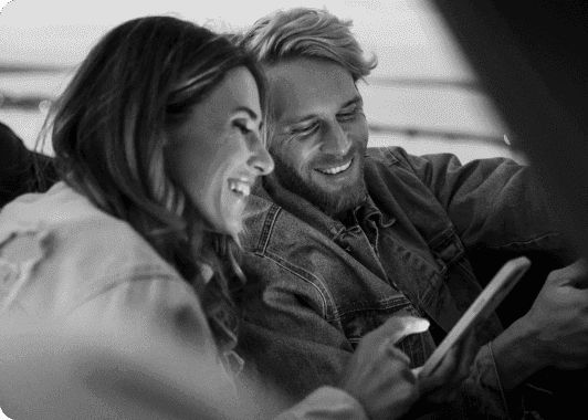 A couple looking at their phone while sitting in a car