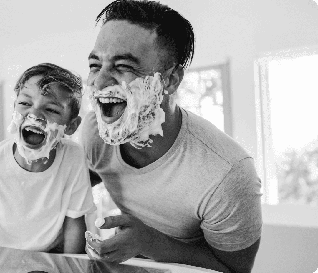 A Dad and son shaving their faces together